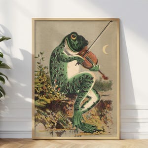 May include: A vintage illustration of a green frog playing a violin. The frog is sitting on a rock with green foliage behind it. The frog is wearing a white shirt and has a black bow tie. The violin is brown and has a white bow. The background is a light brown color with a crescent moon in the upper right corner.
