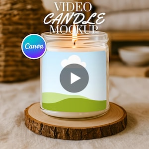 Op de afbeelding: Een brandende kaars in een heldere glazen pot met een label met een afspeelknop over een landschap. De kaars staat op een houten onderzetter. De tekst "VIDEO CANDLE MOCKUP" staat bovenaan en een "Canva"-logo staat links.