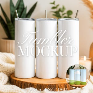 May include: Three white tumblers with silver lids and straws are displayed on a wooden slice. The text "Tumbler MOCKUP" is overlaid on the tumblers. A small inset image shows the tumblers with a color design. The background includes plants and a candle.