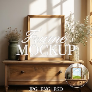 Puede incluir: Maqueta de marco dorado con el texto "Frame Mockup" en escritura blanca. El marco descansa sobre una cómoda de madera, con jarrones de flores secas y una pequeña planta en maceta. También hay una imagen enmarcada más pequeña.