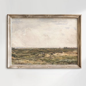 Op de afbeelding: Een ingelijst schilderij dat een landschap met een grasveld, glooiende heuvels en een bewolkte lucht toont. Het schilderij is in een rustieke houten lijst.