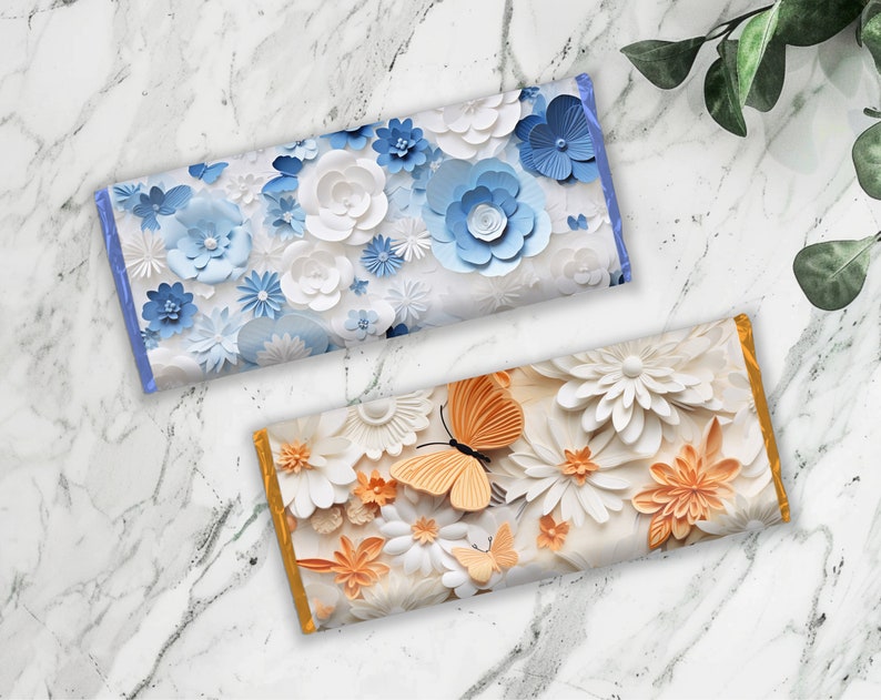 Pu&ograve; includere: Due involucri di barrette di cioccolato con un design floreale. L'involucro superiore presenta fiori di carta blu e bianchi. L'involucro inferiore presenta fiori di carta bianchi e arancioni con farfalle.