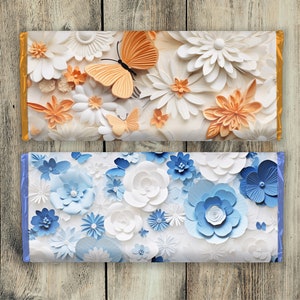 Pu&ograve; includere: Due disegni decorativi di carta da regalo con fiori di carta. Il design superiore presenta fiori di carta bianchi e arancioni con una farfalla. Il design inferiore presenta fiori di carta bianchi e blu.