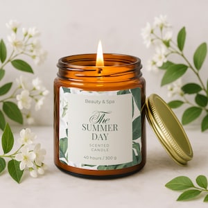 May include: A lit, amber-colored glass jar candle with a gold lid. The label reads "The Summer Day Scented Candle" with a floral design. The candle is surrounded by white flowers and green leaves. The candle burns for 40 hours and weighs 300 grams.