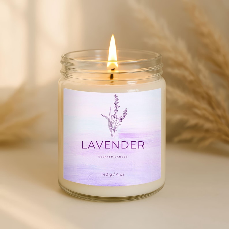 May include: A lit lavender-scented candle in a clear glass jar. The label features a purple watercolor design with a lavender sprig illustration and the text "LAVENDER". The candle weighs 4 oz and 140 g.