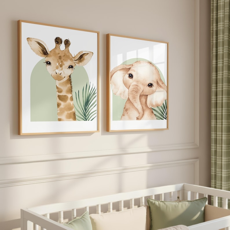 K&ouml;nnte beinhalten: Zwei gerahmte Aquarelldrucke mit einer Giraffe und einem Elefanten. Die Giraffe hat braune Flecken und einen langen Hals, w&auml;hrend der Elefant hellbraun mit gro&szlig;en Ohren ist. Beide sind vor einem hellgr&uuml;nen Hintergrund mit botanischen Akzenten in Holzrahmen.