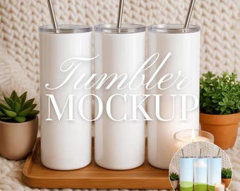 May include: Three white tumblers with silver straws and clear lids are displayed on a wooden tray. The tumblers are in front of a cozy, cream-colored background. The text "Tumbler MOCKUP" is overlaid on the tumblers. A small potted plant and a candle are also in the image.