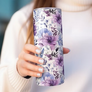 May include: A stainless steel tumbler with a floral pattern featuring purple and blue flowers on a white background.