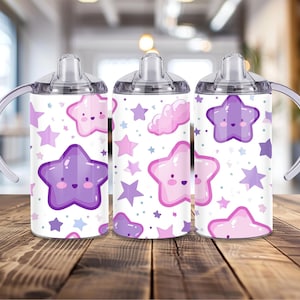 Peut inclure: Trois gobelets &agrave; bec blancs avec un motif d'&eacute;toiles. Le motif comprend des &eacute;toiles souriantes et des nuages dans des tons de violet et de rose. Chaque tasse a un couvercle transparent et une poign&eacute;e incurv&eacute;e.