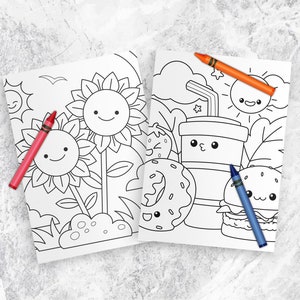 以下が含まれることがあります： ひまわり、ドーナツ、カップ、ハンバーガー、太陽の白黒イラストが描かれた塗り絵2枚。ページは白のテクスチャ加工された表面に、赤、オレンジ、青のクレヨンと一緒に置かれています。