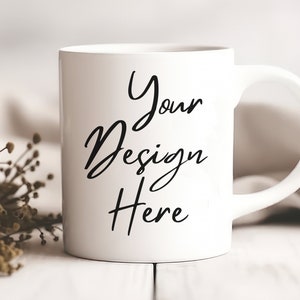 K&ouml;nnte beinhalten: Eine wei&szlig;e Keramiktasse mit einer schwarzen Aufschrift, die "Your Design Here" lautet.