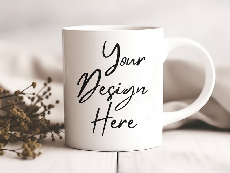 K&ouml;nnte beinhalten: Eine wei&szlig;e Keramiktasse mit einer schwarzen Aufschrift, die "Your Design Here" lautet.