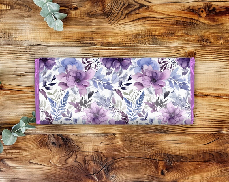 Pu&ograve; includere: Un tessuto con stampa floreale viola e blu su sfondo bianco. Il tessuto ha un bordo viola chiaro.