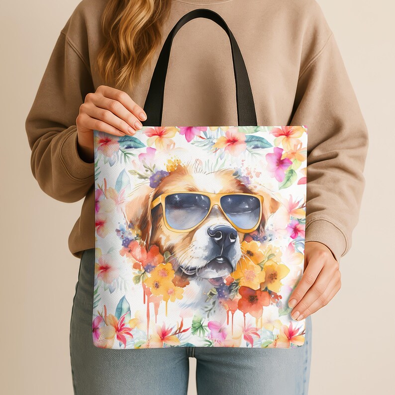 May include: A white tote bag with a watercolor design of a dog wearing sunglasses and surrounded by flowers. The dog is brown and white with a black nose. The flowers are pink, yellow, orange, and red.