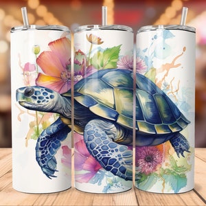 Puede incluir: Tres vasos de acero inoxidable con fondo blanco y un dise&ntilde;o de acuarela de una tortuga marina nadando a trav&eacute;s de un campo de flores rosas, moradas y azules.