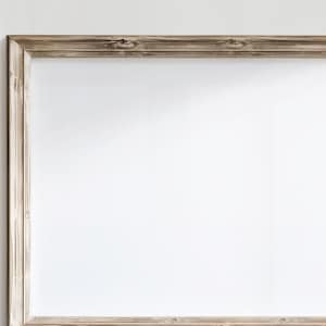 Op de afbeelding: Een eenvoudige, rechthoekige houten lijst met een witte achtergrond. De lijst is gemaakt van lichtbruin hout met een licht verweerde afwerking.