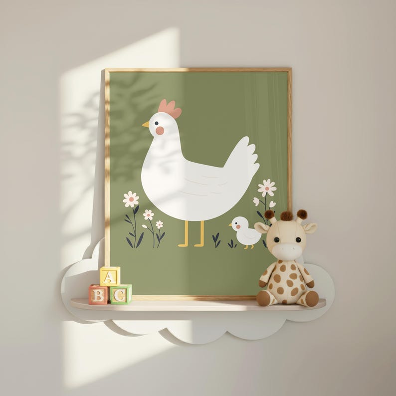 K&ouml;nnte beinhalten: Ein gerahmter Druck mit einer wei&szlig;en Henne und einem K&uuml;ken auf gr&uuml;nem Hintergrund mit wei&szlig;en Blumen. Das Kunstwerk hat einen hellen Holzrahmen und wird &uuml;ber einem wolkenf&ouml;rmigen Regal mit einem Giraffen-Pl&uuml;schtier und ABC-Bl&ouml;cken ausgestellt.