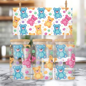 May include: Three clear glass tumblers with bamboo lids and straws. Each tumbler features a colorful cartoon design of teddy bears and polka dots.