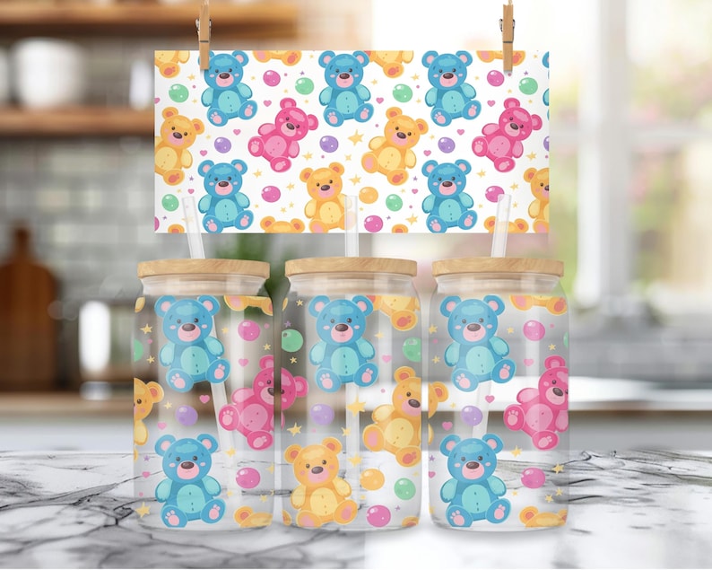 May include: Three clear glass tumblers with bamboo lids and straws. Each tumbler features a colorful cartoon design of teddy bears and polka dots.