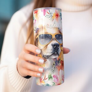 May include: A stainless steel tumbler with a white background and a watercolor illustration of a dog wearing sunglasses and surrounded by flowers.