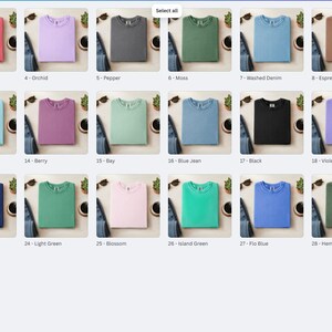 May include: A collection of 30 crew neck t-shirts in various colors, including ivory, coral, and red. Each shirt is neatly folded and displayed with a pair of sunglasses and a denim item. The shirts are arranged in a grid, with color names labeled.