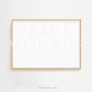 Op de afbeelding: Een eenvoudige, lichte houten frame mockup met een witte achtergrond. De frame staat op een witte muur. De tekst "FRAME MOCKUP" is zichtbaar in de afbeelding.