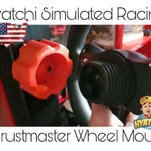 Puede incluir: Un soporte de volante Thrustmaster naranja está fijado a un volante negro. La imagen incluye el texto "Hyatchi Simulated Racing" y un logotipo de dibujos animados. El soporte está diseñado para simulación de carreras.