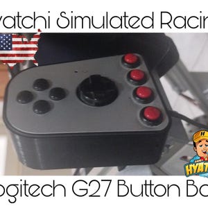 Puede incluir: Una caja de botones negra y plateada con botones rojos y una palanca de mando negra. La caja está etiquetada como "Hyatchi Simulated Racing" y "Logitech G27 Button Box".