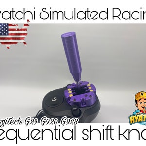 以下が含まれることがあります： ロジテックG29、G920、G923レーシングホイール用の紫色のシーケンシャルシフトノブ。ノブは、ボタンとギアシフターが付いた黒いベースに取り付けられています。