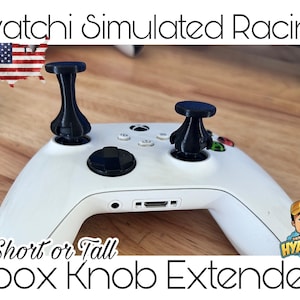 以下が含まれることがあります： 白いXboxコントローラーと黒いノブエクステンダー。画像には「Hyatchi Simulated Racing」と「Short or Tall Xbox Knob Extenders」の文字が含まれています。エクステンダーは黒色で、ユニークなデザインです。