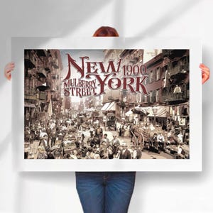 May include: A vintage-style poster featuring a sepia-toned illustration of Mulberry Street in New York City in 1900. The poster has the words "New York" and "Mulberry Street" in a decorative font.
