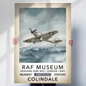 May include: A vintage-style poster featuring a light gray airplane with black propeller and roundels, flying over a stylized seascape. The poster includes the text "RAF MUSEUM" and location details, with "UNDERGROUND STATION" and "COLINDALE" at the bottom.
