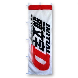 May include: A white banner with a red stripe at the top. The banner has black text that says "INITIAL D" and a large red "D" with black racing stripes. The banner has eyelets on the top and sides.