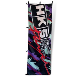 May include: A black banner with a white HKS logo and the words "Power and Sports" in red. The banner has a purple and green abstract design.