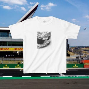 May include: White t-shirt featuring a black and white image of a racing helmet with the words "Red Bull" and "Honda" on it.