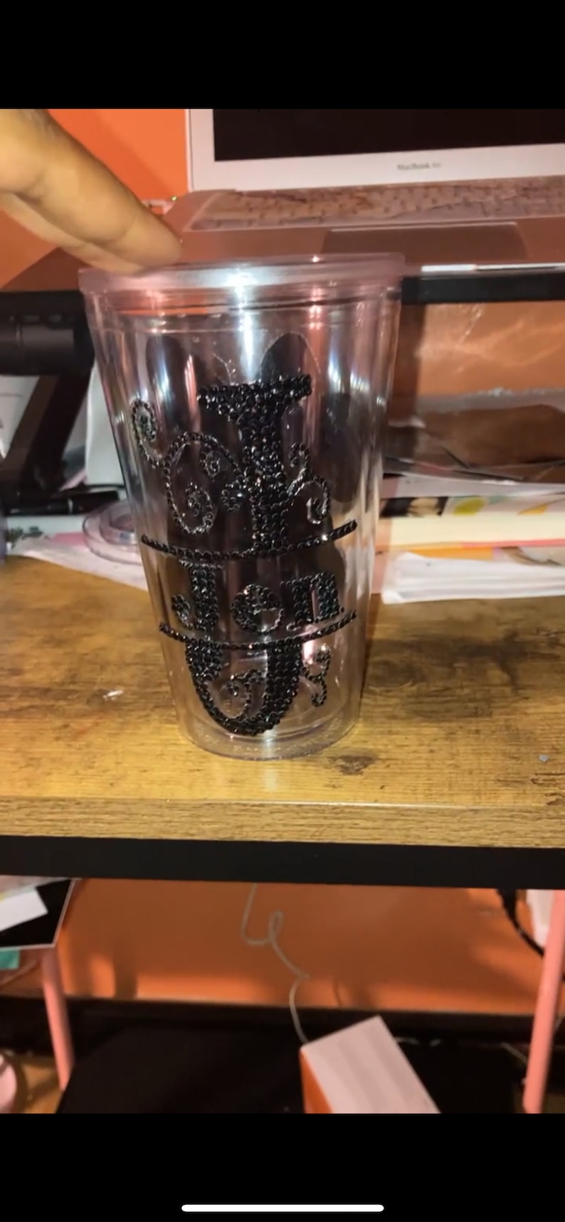 May include: A clear plastic tumbler with a black rhinestone design that spells out the word "Jen".