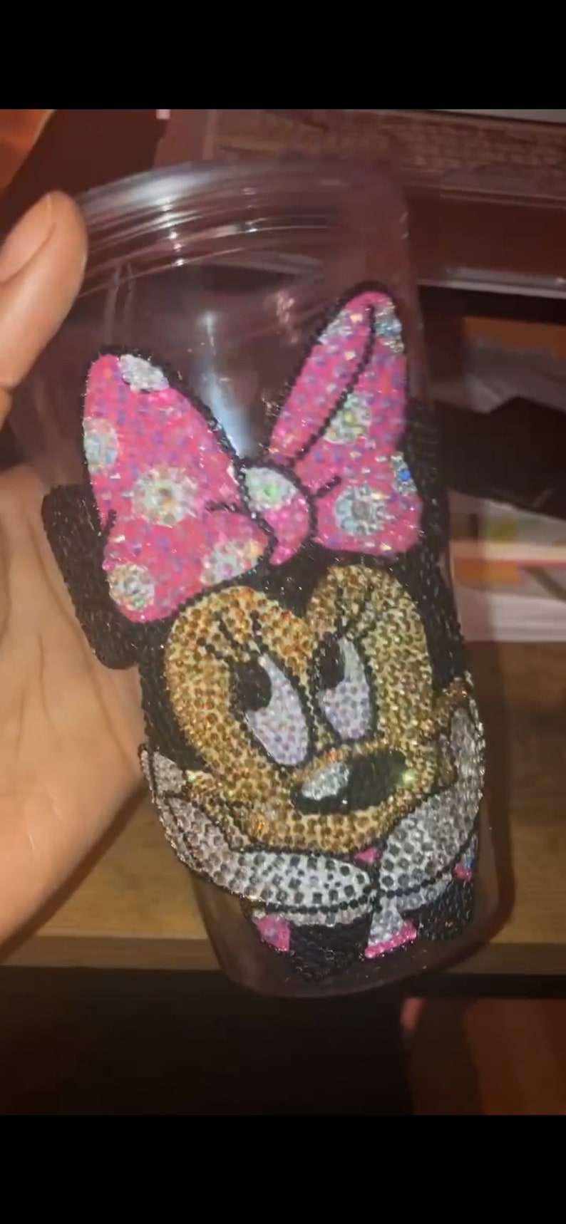 May include: A clear glass tumbler with a pink and black Minnie Mouse design covered in rhinestones.