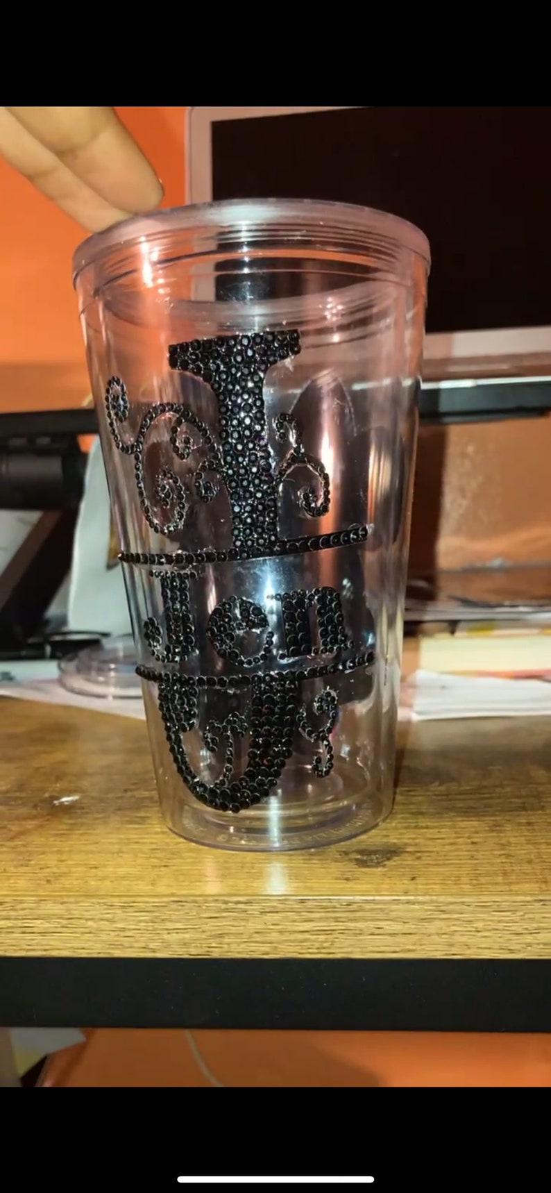 May include: A clear plastic tumbler with a black rhinestone design that says "I Just Got Real".