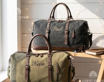 May include: Two canvas duffel bags with brown leather accents and handles. The top bag is charcoal gray with the name Paul embroidered in script. The bottom bag is olive green with the name Kevin embroidered in script. Both feature side pockets.