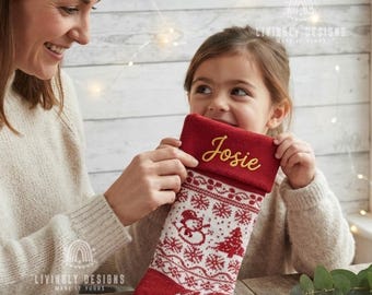 May include: A red and white knit Christmas stocking featuring a repeating pattern of snowmen, snowflakes, and pine trees. The top cuff is solid red with the name Josie embroidered in gold script. The stocking has a soft, textured knit construction.