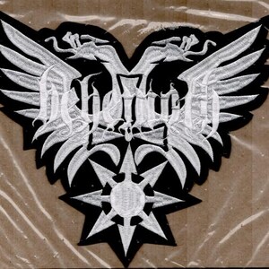May include: A black and white embroidered patch featuring a stylized double-headed eagle design with outstretched wings. The design includes a star at the bottom and ornate lettering in the center. The patch is likely for clothing or accessories.