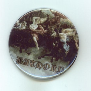 Pode incluir: Um botão redondo com uma pintura escura e detalhada que retrata figuras em movimento. A palavra "BATHORY" é impressa em uma fonte gótica. A obra de arte tem uma estética vintage e antiga.