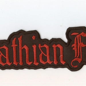 Peut inclure: Un écusson brodé rectangulaire présentant le texte Carpathian Forest dans une police gothique rouge. Les lettres sont cousues sur une base en tissu noir avec une bordure noire assortie qui suit le contour des lettres.