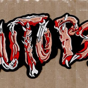 Könnte beinhalten: Gestickter Aufnäher mit dem Wort "AUTOPSY" in einer stilisierten, gotischen Schriftart. Die Buchstaben sind weiß umrandet, mit schwarzem Hintergrund und weisen ein rot-beiges Farbschema auf, das einen blutigen, anatomischen Eindruck vermittelt.