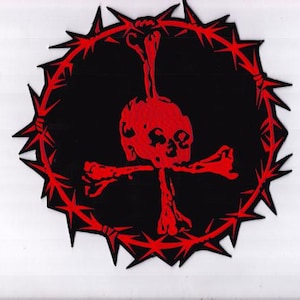Könnte beinhalten: Ein kreisförmiger Aufnäher mit einem roten Totenkopf und gekreuzten Knochen auf schwarzem Hintergrund. Der Totenkopf und die Knochen sind mittig angeordnet und von einem roten, dornigen Kranz umgeben. Der Aufnäher ist wahrscheinlich für Kleidung oder Accessoires bestimmt.