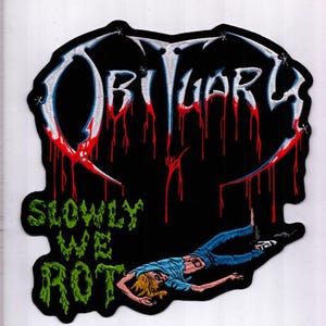 Puede incluir: Parche negro con la palabra "OBITUARY" en blanco y azul, con diseño de goteo de sangre roja. Debajo, el texto verde dice "SLOWLY WE ROT". Una figura en vaqueros azules y camisa azul está tumbada.