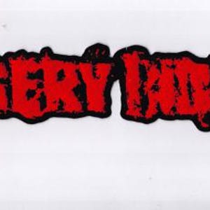 May include: A red and black patch with the text "MISERY INDEX" in a bold, distressed font. The text is in red with a black outline, set against a white background. The patch has a slightly irregular shape.