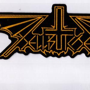 Op de afbeelding: Zwarte patch met gouden rand, met het woord "Hellraiser" in een gestileerd lettertype, met een kruis en een vleermuisvleugelontwerp. Deze patch is waarschijnlijk voor een jas of tas en is een symbool van de heavy metal subcultuur.