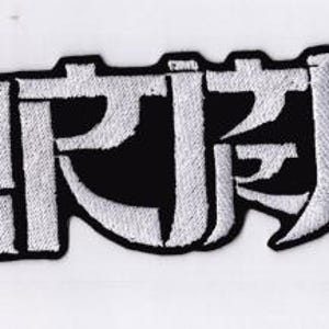 May include: Embroidered patch with white Japanese characters on a black background. The patch has a skull on each end. The text is in a bold, stylized font. The patch is rectangular in shape.