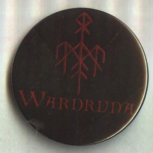 Puede incluir: Un botón redondo, marrón oscuro, con un símbolo rojo y la palabra "WARDRUDA" en letras rojas. El símbolo es un diseño estilizado con líneas verticales y horizontales.
